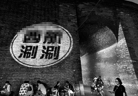 商家用LED射灯将店名、牌匾照在城墙上打广告 本报记者陈飞波摄