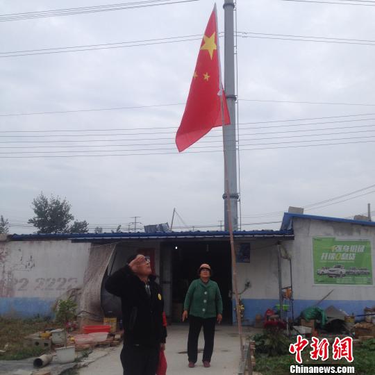 国旗升起后，赵伦波向国旗敬礼。 刘林 摄