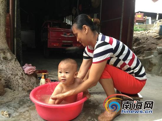 渔嫂杨丽正在用刚投入使用的海水淡化厂生产的淡水给儿子洗澡。南海网记者高鹏摄