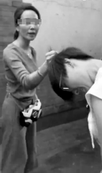 骑车女子（左）揪住刘女士头发。　视频截图